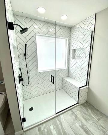 Walk-in shower remodel with white herringbone subway tile and matte black fixtures