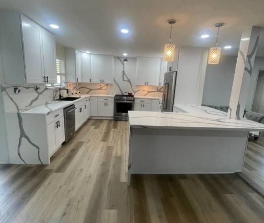 White kitchen remodel with dramatic veined stone countertops and backsplash